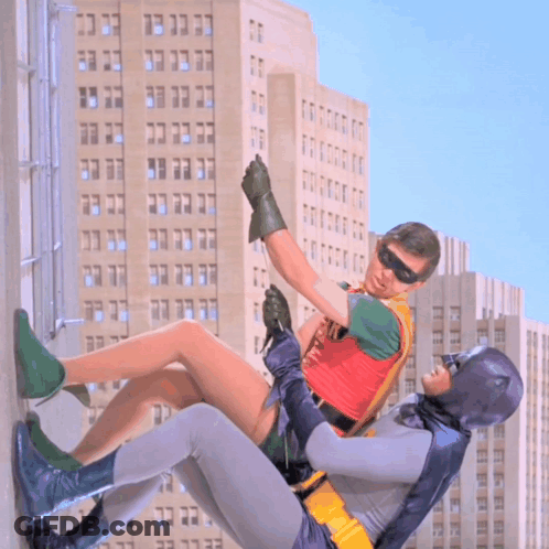 Robin And Batman Fighting In Front Of Building GIF