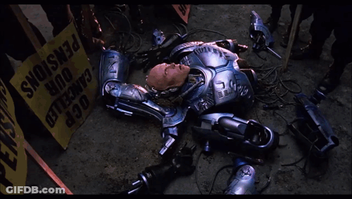 Robot Laying In Front Of Yellow Box Saying OCR GIF