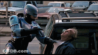 Robot Pointing Gun At Man In Front Of Car With Letter N GIF