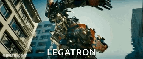 Robot Standing In Front Of Legatron Building GIF