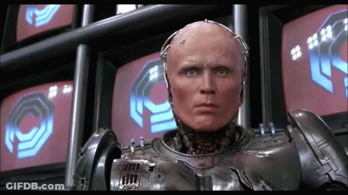 Robot Standing In Front Of Monitors With O GIF