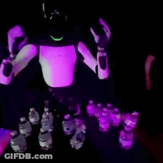 Robot Standing In Front Of Table Full Of Water Bottles GIF