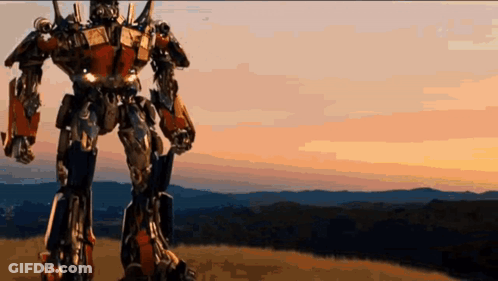 Robot Standing On Hill With Mountains GIF