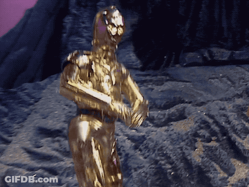 Robot Statue Covered In Gold Powder Purple Background GIF