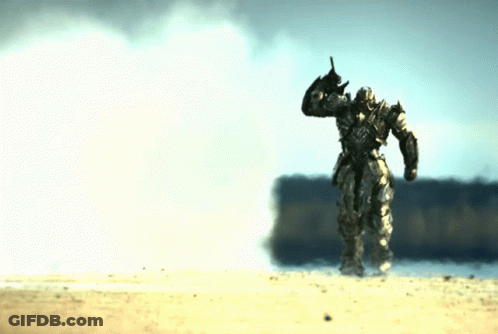 Robot Statue Standing In Sand GIF