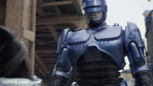 Robot With Helmet In Front Of Building GIF