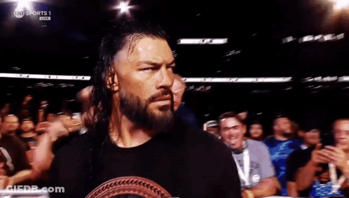 Roman Reigns Is Walking Out Of A Wrestling Ring In Front Of A Crowd GIF