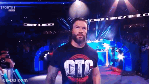 Roman Reigns Is Walking Out Of The Ring Wearing A T-Shirt That Says Gtc On It . GIF