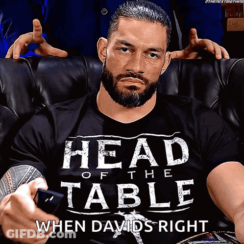 Roman Reigns Is Wearing A Shirt That Says Head Of The Table When Davids Right GIF