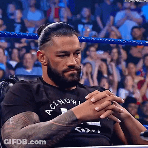 Roman Reigns Sitting In Chair With Hands Folded GIF