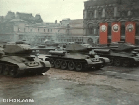 Row Of Black And White Tanks Driving In Snow GIF
