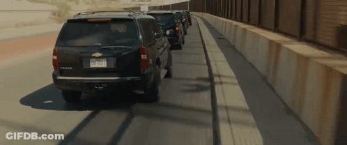 Row Of Cars On Highway Near Fence GIF