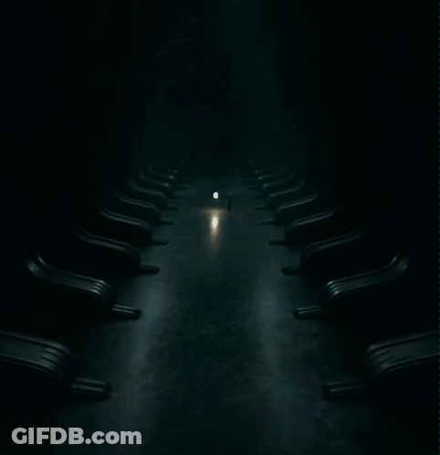 Row Of Chairs In Dark Room With Light GIF