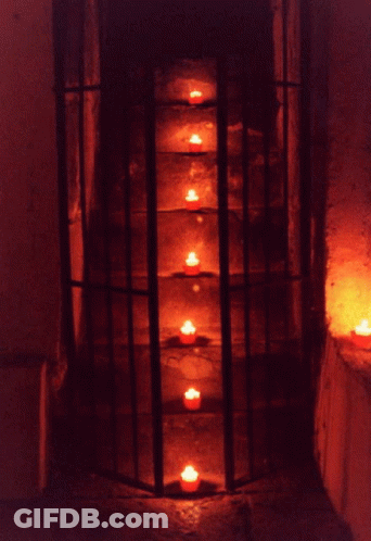 Row Of Lit Candles In A Cage GIF