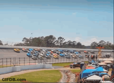 Row Of Race Cars Lined Up On Track GIF