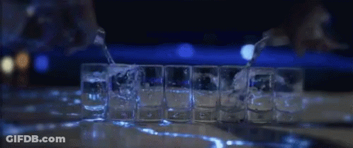 Row Of Shot Glasses Lined Up On Bar GIF