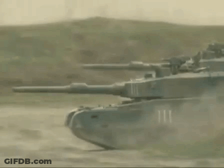 Row Of Tanks Driving Down Dirt Road GIF