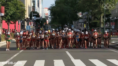 Runners Running Down Street With Olympic Rings GIF