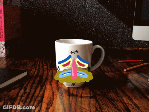 Sad Face Mug On Wooden Desk GIF