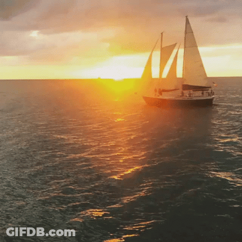 Sailboat In Ocean At Sunset GIF