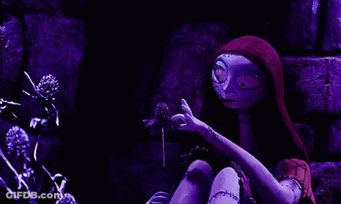 Sally From The Nightmare Before Christmas Is Holding A Flower In Her Hands . GIF