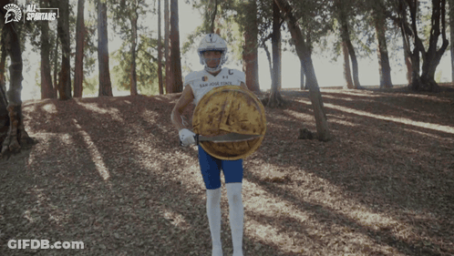 San Diego State Football Player Holding Shield In Woods GIF