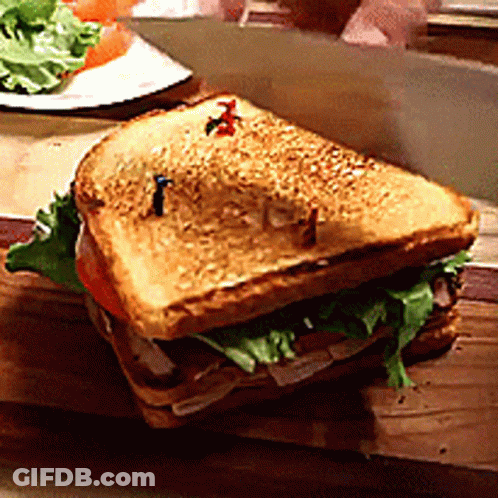 Sandwich With Lettuce And Tomatoes On Cutting Board GIF