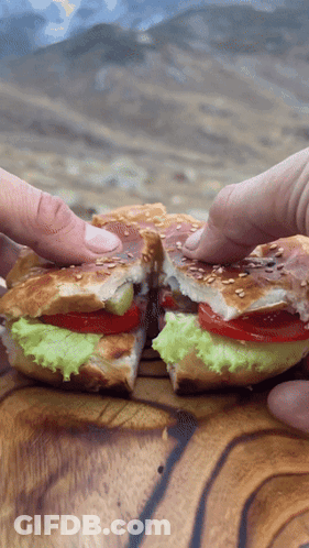 Sandwich With Lettuce Tomatoes And Sesame Seeds Cut In Half GIF
