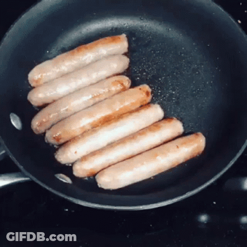 Sausages Are Cooking In A Frying Pan On The Stove GIF
