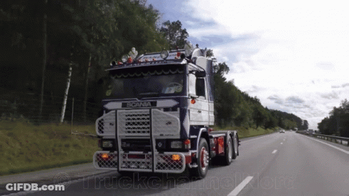 Scania Truck Driving Down Highway With Trees GIF
