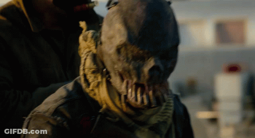 Scarecrow With Scarf Held By Man In Brown Jacket GIF