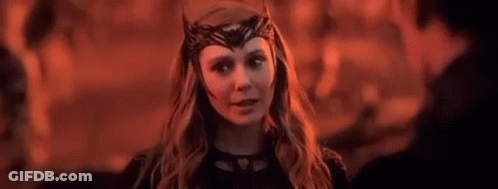 Scarlet Witch Is Wearing A Crown On Her Head And Looking At A Man In A Dark Room . GIF