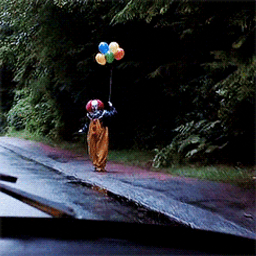 Scary Clown Holding Balloons In Roadside GIF