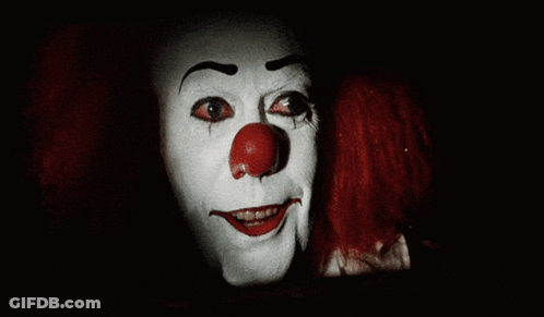 Scary Clown Red Eyes Facing Man In Suspenders GIF