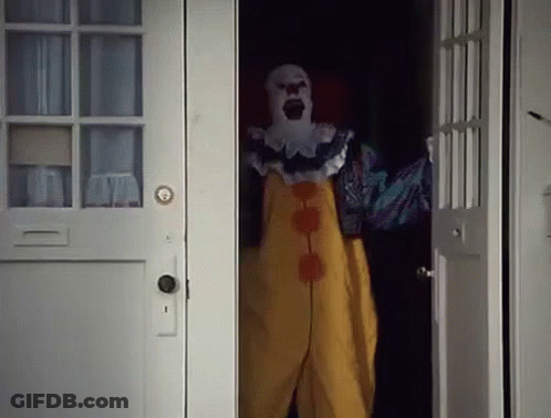 Scary Clown Standing In Dark Doorway GIF