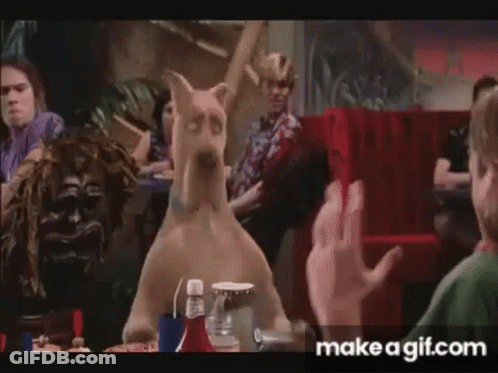 Scooby Doo Is Sitting At A Table In A Diner With A Group Of People . GIF