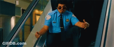 Security Guard Sitting On Escalator Wearing Sunglasses GIF