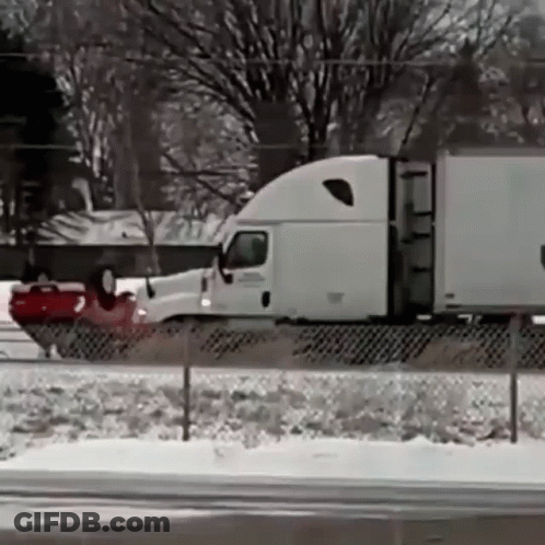Semi Truck Driving On Snow Covered Highway GIF