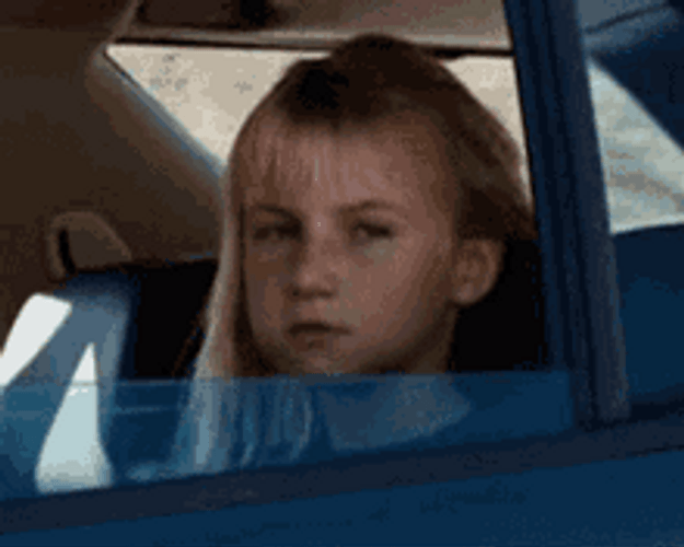 Serious Little Girl Riding Car Flipping Off GIF