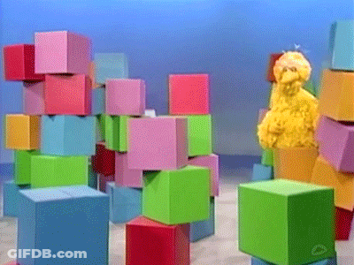 Sesame Street Big Bird Standing In Front Of A Stack Of Blocks GIF