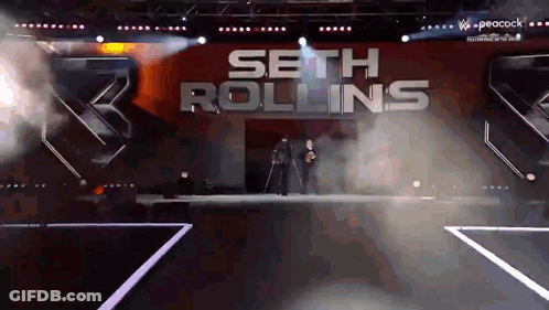 Seth Rollins Is Walking Down The Aisle Of A Stage GIF
