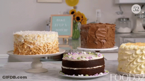 Several Cakes On A Table With A Sign That Says Bake It 'S A Special Day GIF