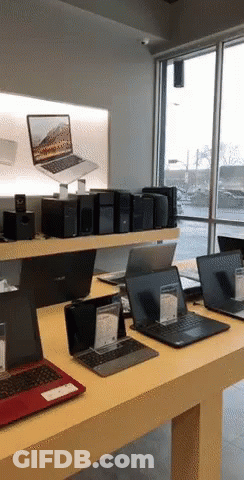 Several Laptops Are On Display In A Store Including One From Asus GIF