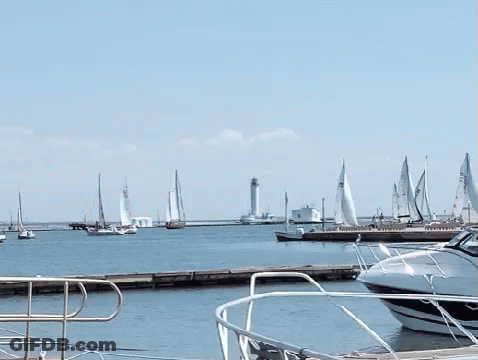 Several Sailboats Are Docked In A Harbor And One Of Them Has A Sail That Says ' A ' On It GIF