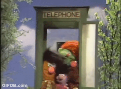 Several Sesame Street Characters Are In A Telephone Booth . GIF