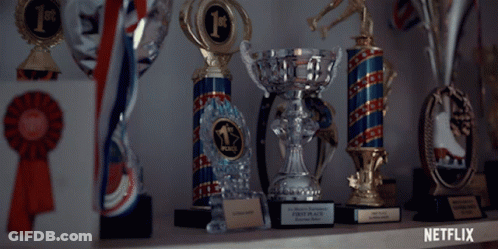 Several Trophies Are Lined Up On A Shelf And One Of Them Says First Place GIF