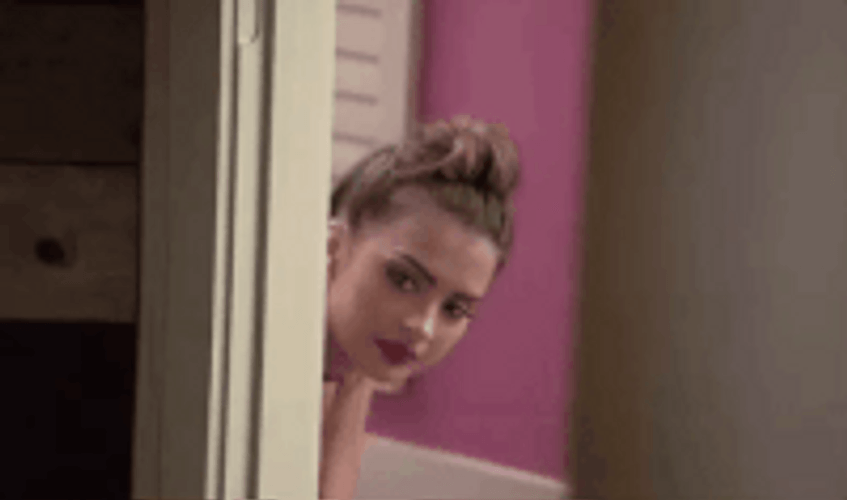 Sexy Lady Peeking Behind The Door GIF