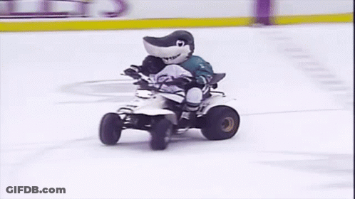 Shark Mascot Riding Four Wheeler On Ice Rink GIF