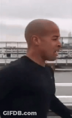 Shaved Head Man Walking In Black Shirt GIF