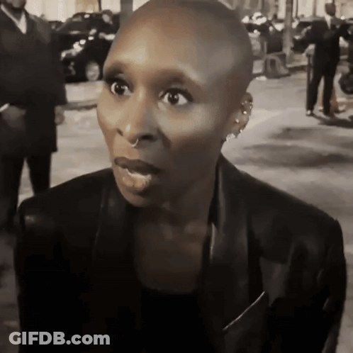 Shaved Head Woman In Earrings And Black Jacket GIF